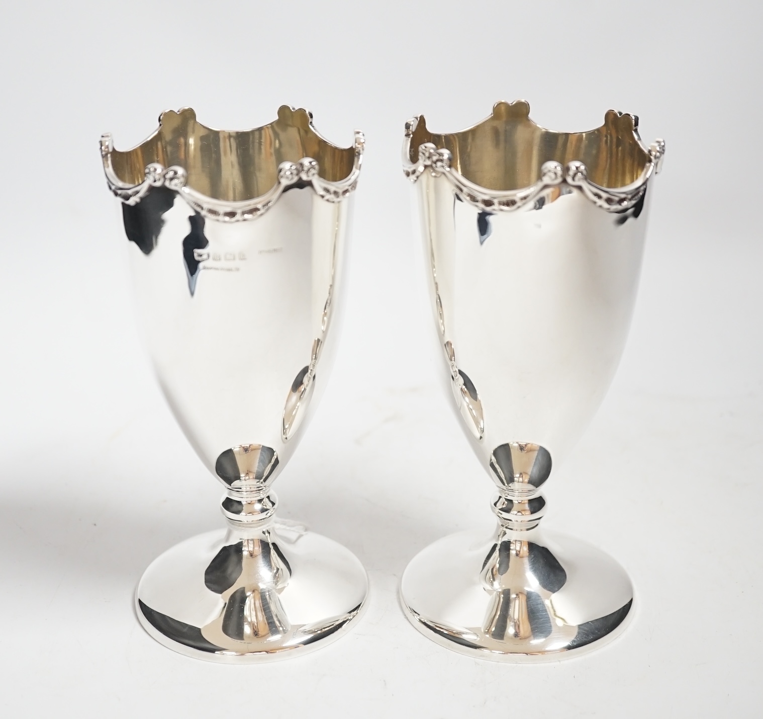 A pair of Edwardian silver pedestal vases, by Mappin & Webb, Birmingham, 1909, 17.1cm, 13.7oz.